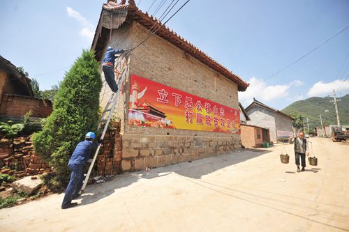 為確保濟(jì)源玉皇廟村電力供應(yīng)更可靠，濟(jì)源供電公司自5月份就開始對該村電網(wǎng)升級改造，施工人員克服山高坡陡、住戶分散、室外高溫等不利條件，日夜奮戰(zhàn)在工地，目前工程已接近尾聲。圖為7月20日，該公司人員正在接村民下戶線