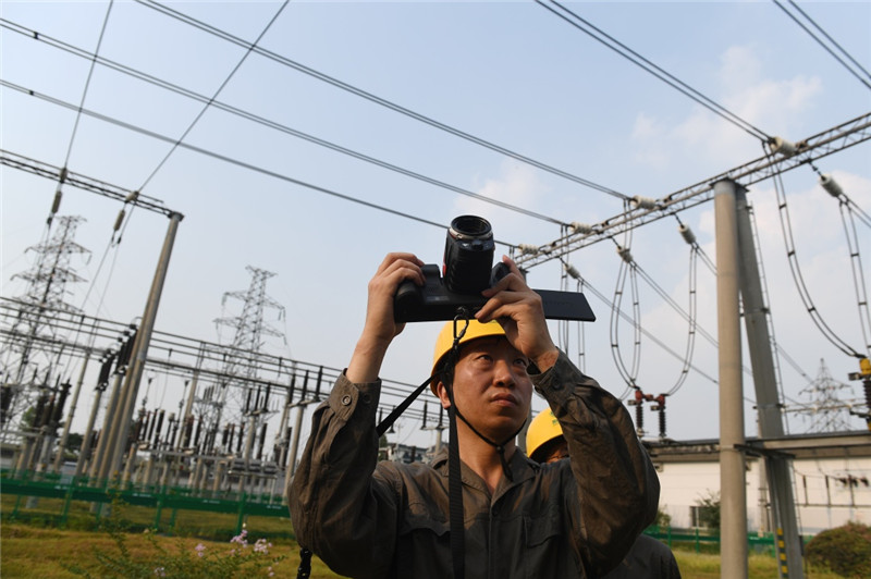 7月25日，在杭州市220千伏鳳凰變電站，運(yùn)行維護(hù)人員手持紅外熱像儀對(duì)變電站設(shè)備進(jìn)行測(cè)溫。持續(xù)的高溫天氣，促使浙江省用電負(fù)荷不斷攀升