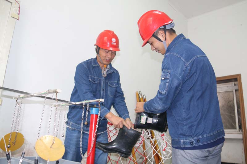 9月7日，光山縣供電公司員工向國富、楊曉偉正在通過耐壓試驗(yàn)裝置開展絕緣靴的預(yù)防性周期試驗(yàn)。這是該公司加強(qiáng)安全工器具管理的一個(gè)場(chǎng)景，確保所有的安全工器具“健康上崗”