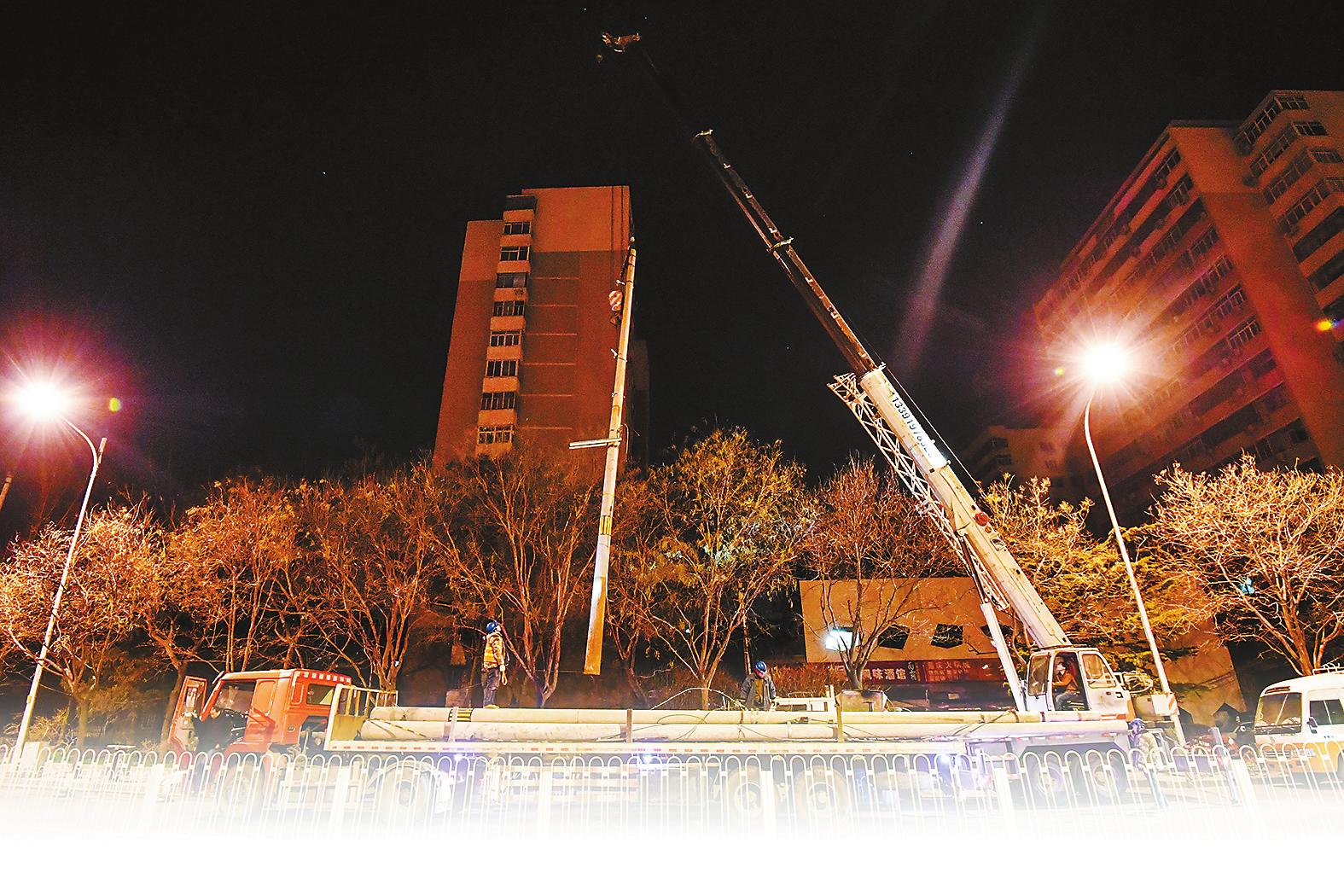 
　　12月13日凌晨2時(shí)，北京市西城區(qū)白云路上，伴隨著吊車的轟鳴聲，國網(wǎng)北京電力的工作人員在零下11攝氏度的環(huán)境中進(jìn)行電線桿拆除作業(yè)。 范超 攝

　　12月13日凌晨2時(shí)，零下11攝氏度，北京市西城區(qū)二環(huán)邊的白云路，寒霜氤氳街道，伴隨著手指凍麻至無知覺，桿頂作業(yè)的電力工人小張又一次無奈地停下手中拆除電桿的活兒，向著雙手用力哈了幾口熱氣