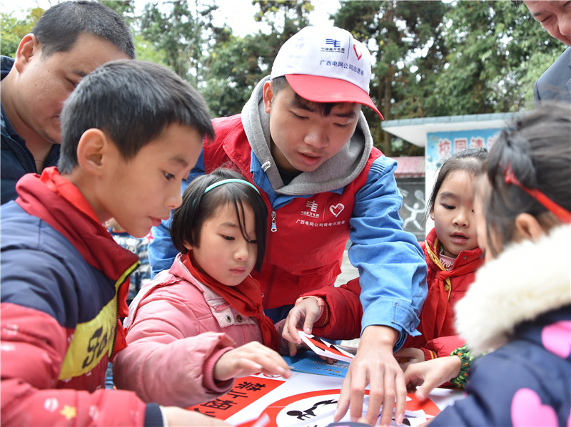 
　　青年志愿者在指導(dǎo)學(xué)生進(jìn)行安全警示標(biāo)志拼圖，通過趣味游戲增強(qiáng)孩子們的安全用電意識。（陸婕 攝）

　　青年志愿者用生動有趣的漫畫向?qū)W生講解安全用電知識（陸婕 攝）

　　本網(wǎng)訊 利用漫畫讀物展示安全用電小常識、現(xiàn)場提問搶答……12月15日，南方電網(wǎng)廣西公司聯(lián)合廣西壯族自治區(qū)司法廳，創(chuàng)新機(jī)制實(shí)施“精準(zhǔn)扶貧+普法”的形式，在廣西東蘭縣隘洞鎮(zhèn)香河小學(xué)開展“電力普法進(jìn)校園 心系兒童保安全”為主題的法制宣傳活動，將安全用電知識和電力設(shè)施