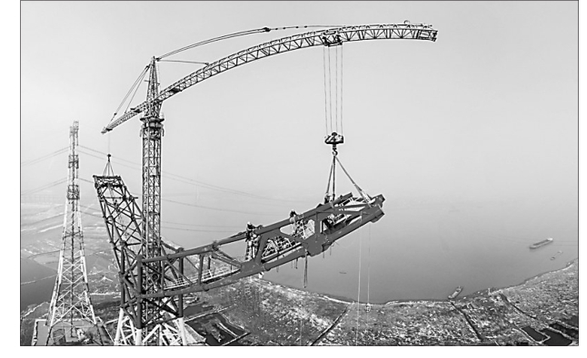 
            	2月6日，在安徽省繁昌縣荻港鎮(zhèn)，跨越塔在進(jìn)行橫擔(dān)就位施工（無(wú)人機(jī)航拍，拼接照片）。當(dāng)日，世界上輸電距離最長(zhǎng)、輸電量最大、電壓等級(jí)最高的輸電工程――昌吉―古泉±1100千伏特高壓直流輸電工程長(zhǎng)江大跨越工程南岸跨越塔成功封頂