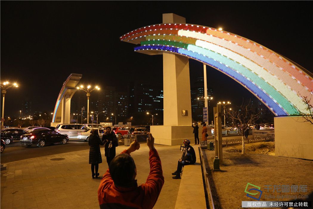 
            	2月8日農(nóng)歷臘月二十三，熄滅了75天的彩虹門重新亮燈，彩虹跨越長(zhǎng)安街，節(jié)日的味道更濃了。晚上六點(diǎn)，北京長(zhǎng)安街復(fù)興門、建國門新版彩虹橋正式點(diǎn)亮，紅、橙、黃、綠、藍(lán)“七彩之光”不時(shí)變換著各種狀態(tài)散發(fā)光芒，吸引了不少市民駐足欣賞，合影留念