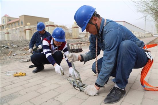 
　　楊盛治（右一）和同事在施工現(xiàn)場打拉線。

　　日前，在新疆生產(chǎn)建設(shè)兵團(tuán)第二師鐵門關(guān)市盛鐵一線負(fù)荷轉(zhuǎn)移供電工程“大會(huì)戰(zhàn)”施工現(xiàn)場，楊盛治與同事張勇民徒手攀爬至18米高的鐵塔，歷時(shí)三個(gè)小時(shí)完成10千伏6回線路轉(zhuǎn)接高空作業(yè)