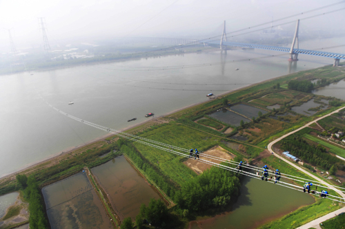 
                        

準(zhǔn)東—皖南特高壓長(zhǎng)江大跨越工程現(xiàn)場(chǎng)。
　　4月15日，在安徽省無為縣高溝鎮(zhèn)長(zhǎng)江北岸，一排排導(dǎo)線在張力機(jī)作用下緩緩向長(zhǎng)江南岸牽引場(chǎng)釋放