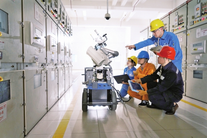 
　　研發(fā)團(tuán)隊(duì)正在調(diào)試南網(wǎng)二代變電站智能巡檢機(jī)器人“阿童木”，該機(jī)器人不僅能巡視，還能自主檢修?！O嘉彪 攝

　　500千伏文山站繼保室機(jī)器人掛在天花板上，“脖子”（懸掛巡檢部分）可以伸很長(zhǎng)，能看清保護(hù)柜的每一個(gè)位置