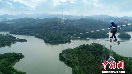 　　電網(wǎng)工人在百米高空進(jìn)行工程安裝作業(yè)。　沈甸　攝　　南方電網(wǎng)廣東東莞縱江變電站配套500千伏線路二期工程6月28日竣工投運(yùn)