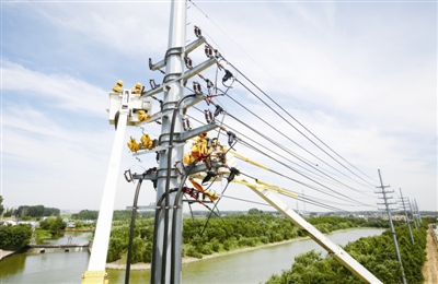                                     　　            　　6月26日午間13時(shí)20分，合肥電網(wǎng)最大負(fù)荷攀升至556.8萬(wàn)千瓦，今夏首次打破6月歷史紀(jì)錄，合肥電網(wǎng)自此全面進(jìn)入迎峰度夏期間。圖為合肥供電公司人員在肥東縣臨河路10千伏電桿上冒高溫開(kāi)展帶電作業(yè)