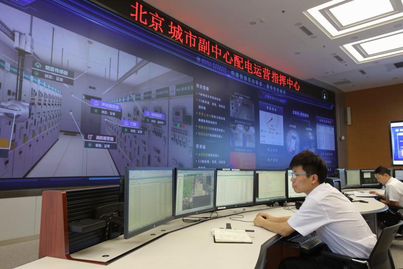 國網(wǎng)北京電力工作人員通過高端智能配電網(wǎng)綜合可視化平臺監(jiān)測北京城市副中心電力設(shè)備運行情況  杜敏/攝　　今年，北京電網(wǎng)負荷雖然連續(xù)4次創(chuàng)歷史新高，但電網(wǎng)整體運行平穩(wěn)。這與國網(wǎng)北京市電力公司從電網(wǎng)規(guī)劃、設(shè)計、建設(shè)、運營、服務(wù)等全方位打造智能電網(wǎng)不無關(guān)系