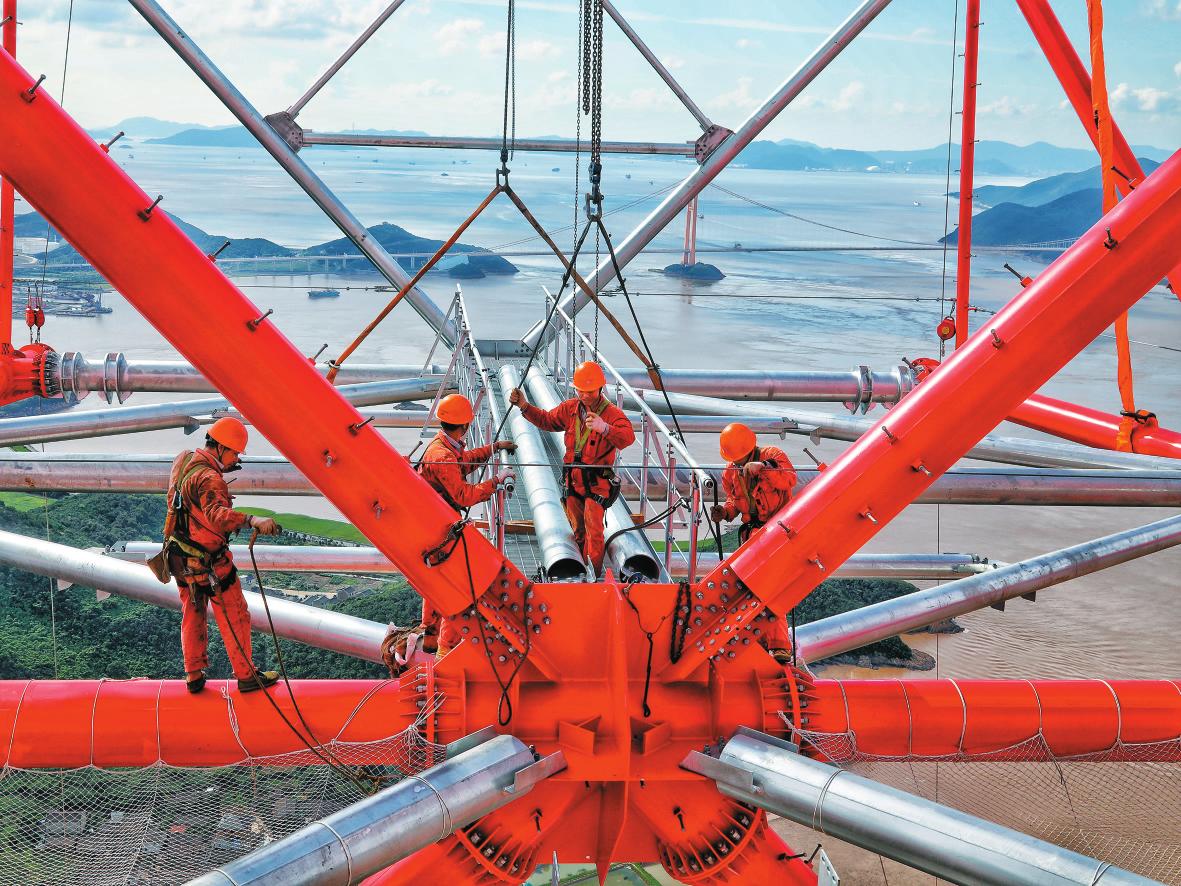 　　9月10日上午，在浙江省舟山市定海區(qū)冊(cè)子島海邊的380米世界第一輸電高塔施工現(xiàn)場(chǎng)，兩段單側(cè)重量為23.15噸的塔頭橫擔(dān)組合件被緩緩吊至度標(biāo)高302米，等候在塔身上的電力工人立即展開(kāi)緊固作業(yè)。據(jù)了解，380米世界第一輸電高塔是舟山500千伏聯(lián)網(wǎng)輸變電工程的關(guān)鍵節(jié)點(diǎn)，在金塘島和冊(cè)子島各建一座