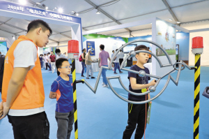 
　　小朋友在志愿者的指導(dǎo)下體驗(yàn)電流棒。閆文麗 攝

　　參觀者利用風(fēng)光儲(chǔ)輸VR設(shè)備體驗(yàn)清潔能源發(fā)電場景